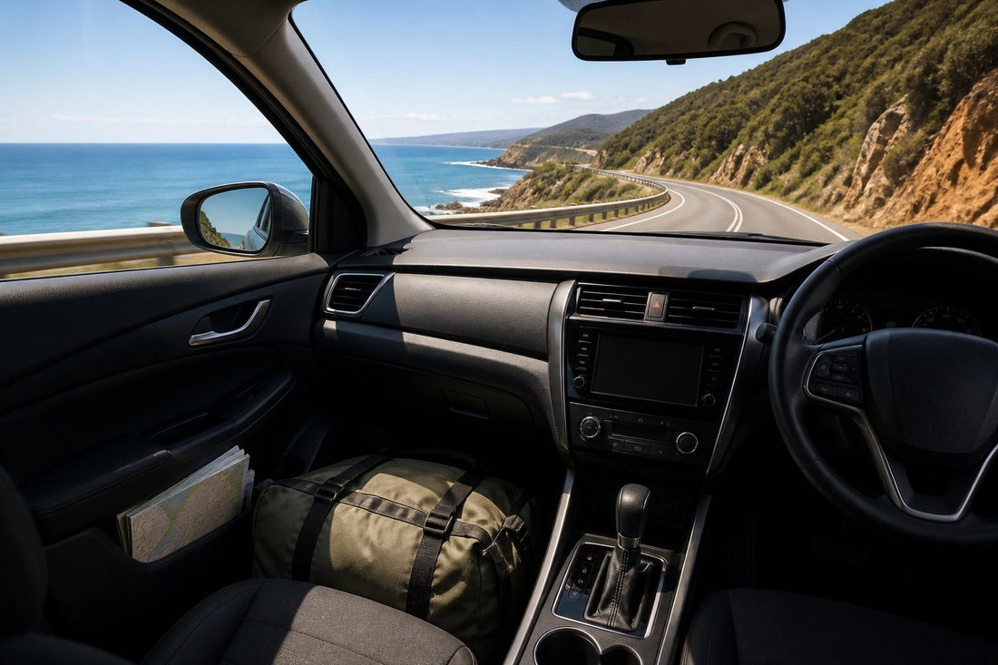 Right-hand-drive car on an Australian coastal highway with a secured overnight bag and map inside