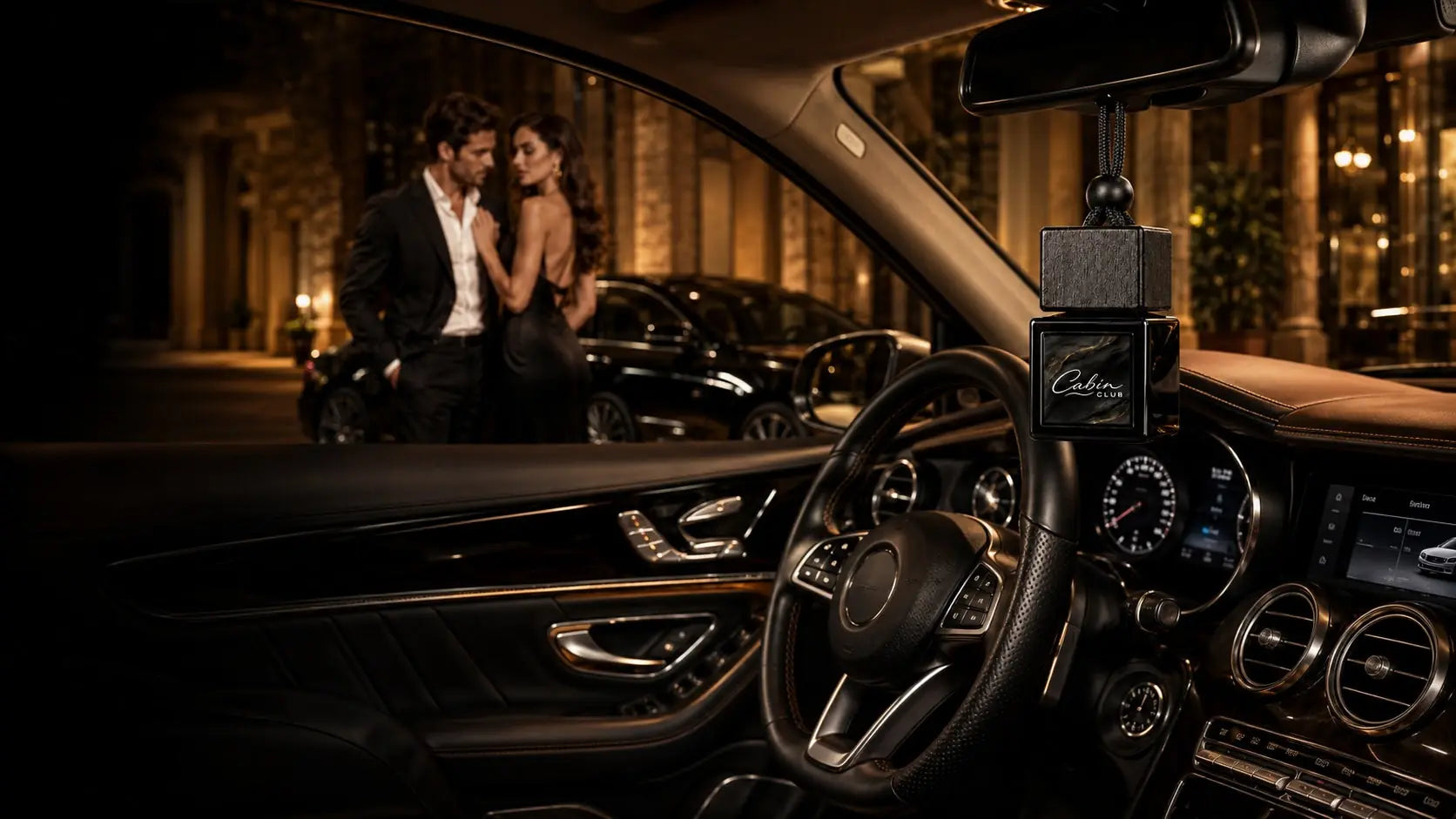 Cabin Club car fragrance diffuser hanging from a luxury car's rear-view mirror with a couple outside a hotel